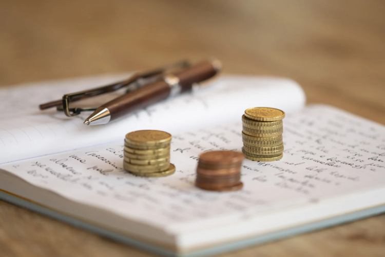 Auf diesem Bild ist ein Notizblock mit Münzgeld zu sehen. 