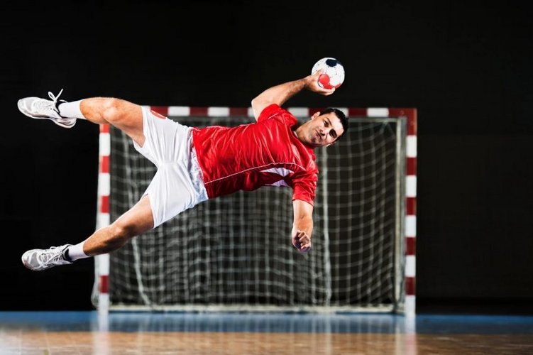 Auf diesem Bild spielt ein Mann Handball und befindet sich gerade im Wurf.