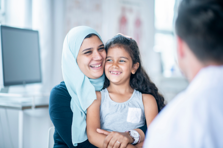Auf dem Bild sind eine Frau mit Kopftuch und ein kleines Mädchen zu sehen.