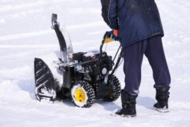 Auf diesem Bild räumt eine Person mit einer Schneefräse den Schnee weg.