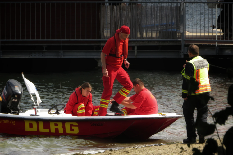 Auf diesem Bild ist ein Boot der DLRG zu sehen, auf dem Personen sitzen.