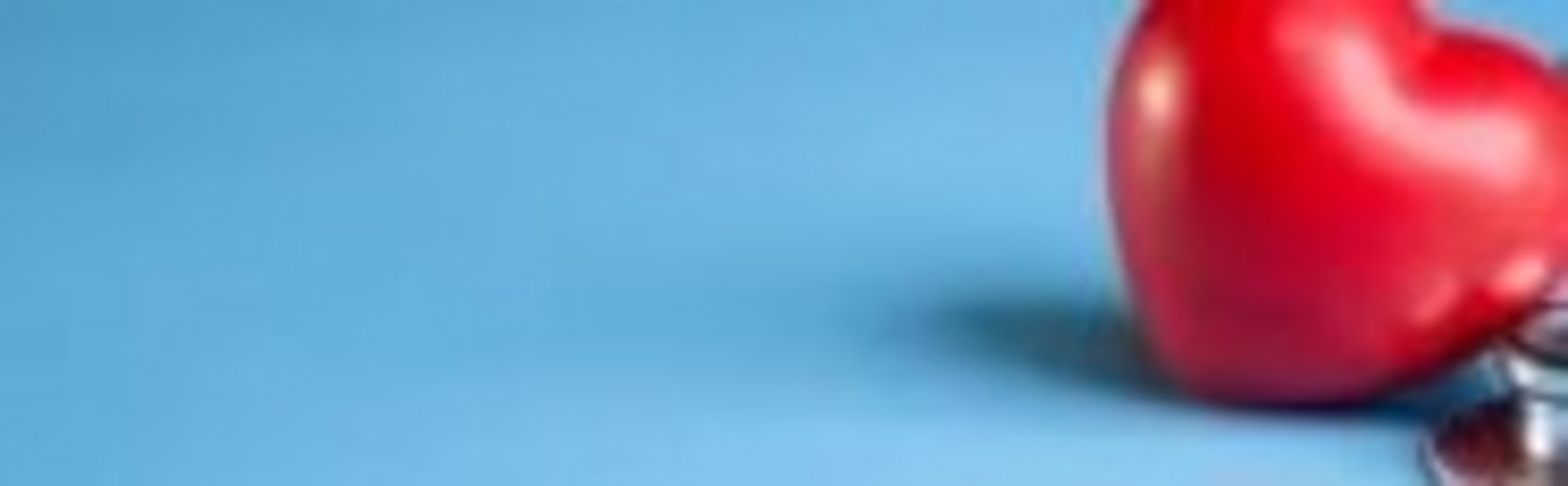 Auf diesem Bild sitzt eine Person mit einem Stethoskop um dem Hals an einem Tisch. Auf dem Tisch liegen Klötzchen mit Symbolen aus dem Gesundheitsbereich, wovon eins hochgehoben wird. 