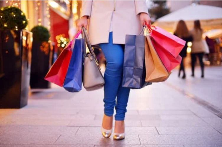 Auf diesem Bild ist eine Frau mit verschiedenen Einkaufstaschen zu sehen.