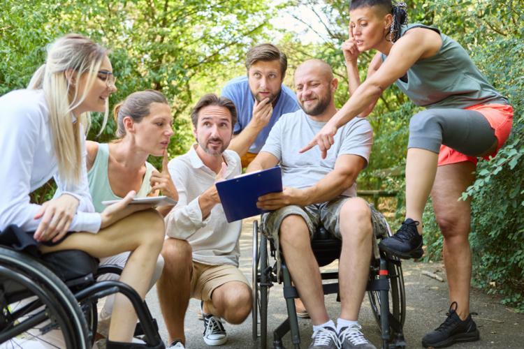 Auf diesem Bild ist eine kleine Gruppe von Menschen mit und ohne Beeinträchtigungen zu sehen.