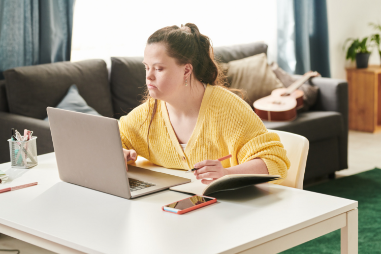 Auf dem Bild ist eine Person mit Down-Syndrom in der häuslichen Umgebung zu sehen. 