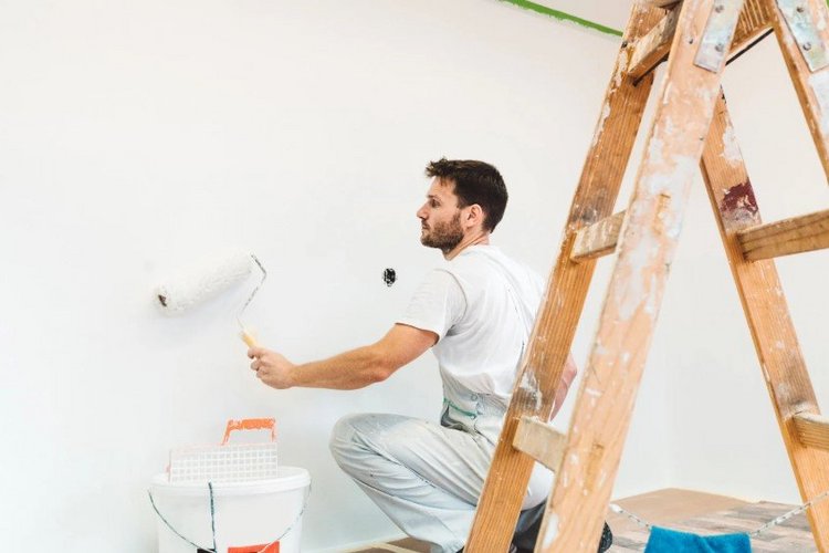 Auf diesem Bild streicht ein Maler eine Wand. 