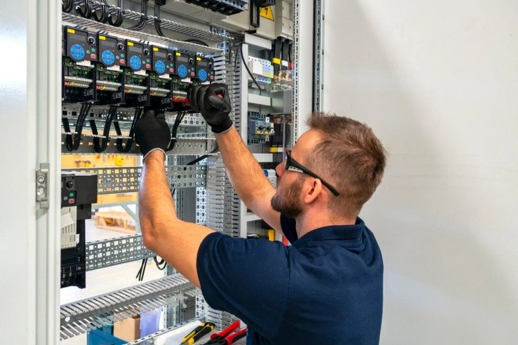 Auf diesem Bild arbeitet ein Mann an einem Sicherungskasten.