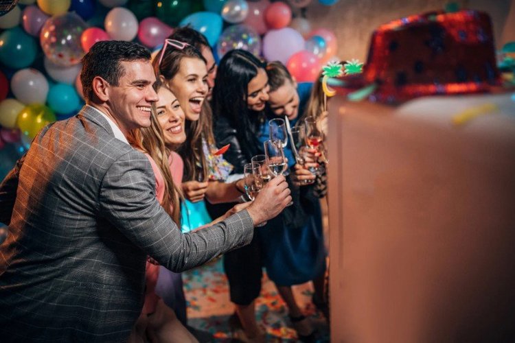 Auf diesem Bild stehen verschiedene Personen auf einer Feier für ein Foto zusammen. 