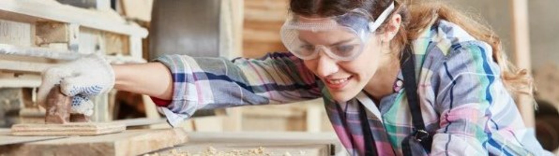 Auf diesem Bild ist eine Frau bei der Bearbeitung von Holz zu sehen.